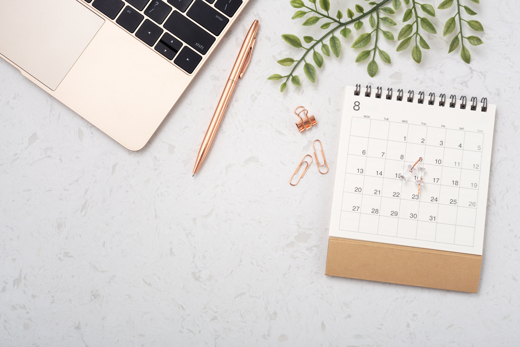Calendar with laptop on white quartz table